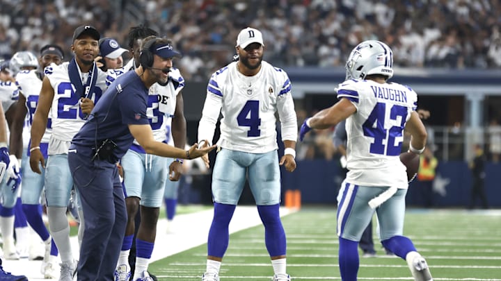 Dallas Cowboys coach Brian Schottenheimer celebrates a touchdown with Dak Prescott and running back Deuce Vaughn.