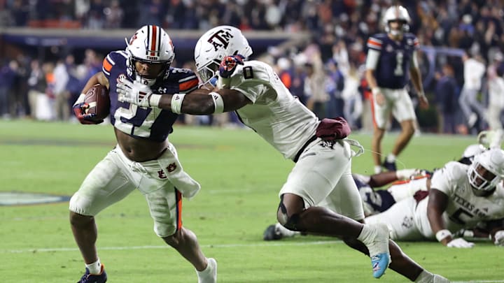 Nov 23, 2024; Auburn, Alabama, USA;  Auburn Tigers running back Jarquez Hunter (27) is chased by Texas A&M Aggies linebacker Scooby Williams (0) during the fourth quarter at Jordan-Hare Stadium. Mandatory Credit: John Reed-Imagn Images