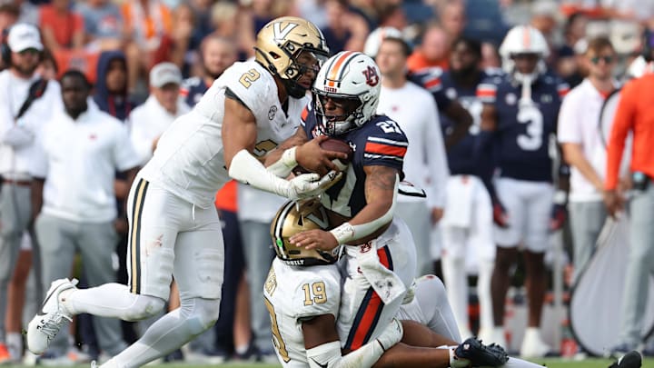 Nov 2, 2024; Auburn, Alabama, USA; Auburn Tigers running back Jarquez Hunter (27) is tackled by Vanderbilt Commodores safety De'Rickey Wright (19) and safety Randon Fontenette (2) during the fourth quarter at Jordan-Hare Stadium. Mandatory Credit: John Reed-Imagn Images