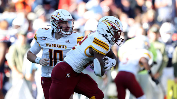 Nov 16, 2024; Auburn, Alabama, USA;  Louisiana Monroe Warhawks quarterback Aidan Armenta (10) hands off to running back Ahmad Hardy (22) during the third quarter against the Auburn Tigers at Jordan-Hare Stadium. Mandatory Credit: John Reed-Imagn Images