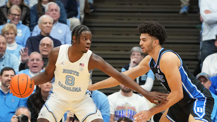 Feb 7, 2026; Chapel Hill, North Carolina, USA; North Carolina Tar Heels forward Caleb Wilson (8) with the ball as Duke Blue Devils forward Cameron Boozer (12) defends in the first  half at Dean E. Smith Center. Mandatory Credit: Bob Donnan-Imagn Images