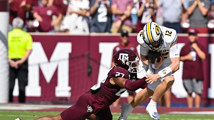 Oct 5, 2024; College Station, Texas, USA; Texas A&M Aggies linebacker Daymion Sanford (27) tackles Missouri Tigers quarterback Brady Cook (12) in the first quarter at Kyle Field. Mandatory Credit: Maria Lysaker-Imagn Images. 