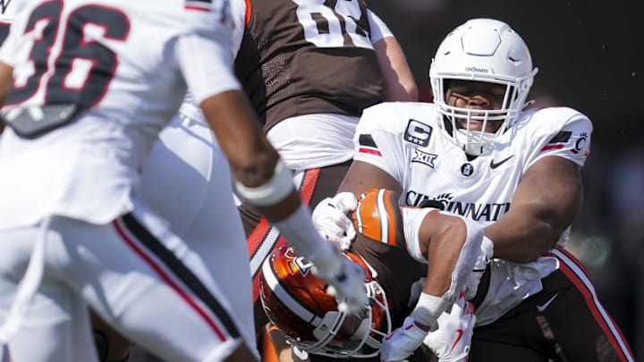 Sep 6, 2025; Cincinnati, Ohio, USA; Cincinnati Bearcats defensive lineman Dontay Corleone (2) tackles Bowling Green Falcons running back Kaderris Roberts (0) in the first half at Nippert Stadium. Mandatory Credit: Aaron Doster-Imagn Images