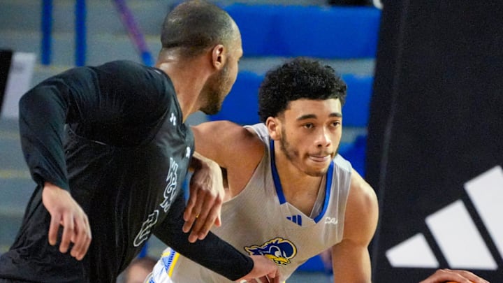 Delaware's Izaiah Pasha (right) pushes the ball to the Hens' end against William and Mary's Caleb Dorsey in the second half of the Blue Hens' 74-64 win at the Bob Carpenter Center, Saturday, Feb. 8, 2025.
