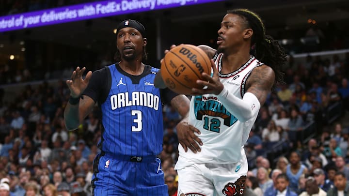 Oct 26, 2024; Memphis, Tennessee, USA; Memphis Grizzlies guard Ja Morant (12) passes the ball as Orlando Magic guard Kentavious Caldwell-Pope (3) defends during the second half at FedExForum. Mandatory Credit: Petre Thomas-Imagn Images