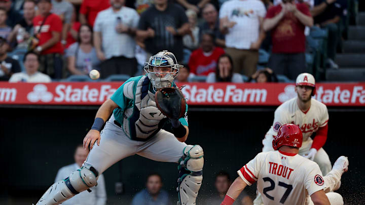 Los Angeles Angels center fielder Mike Trout (27) slides home to score against Seattle Mariners catcher Cal Raleigh (29) on a RBI double by two-way player Shohei Ohtani (not pictured) during the first inning at Angel Stadium in 2022. Los Angeles Angels center fielder Mike Trout (27) slides home to score against Seattle Mariners catcher Cal Raleigh (29) on a RBI double by two-way player Shohei Ohtani (not pictured) during the first inning at Angel Stadium in 2022.
