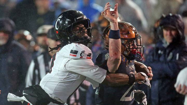 Jan 2, 2026; Memphis, TN, USA; Navy Midshipmen slotback Eli Heidenreich (22) runs the ball as Cincinnati Bearcats defensive back Matthew McDoom (0) makes the tackle during the fourth quarter at Simmons Bank Liberty Stadium. Mandatory Credit: Petre Thomas-Imagn Images Jan 2, 2026; Memphis, TN, USA; Navy Midshipmen slotback Eli Heidenreich (22) runs the ball as Cincinnati Bearcats defensive back Matthew McDoom (0) makes the tackle during the fourth quarter at Simmons Bank Liberty Stadium. Mandatory Credit: Petre Thomas-Imagn Images