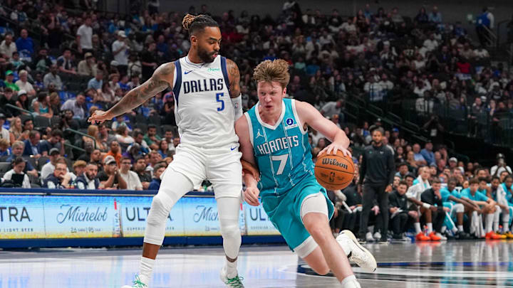 Oct 11, 2025; Dallas, Texas, USA; Charlotte Hornets guard/forward Kon Knueppel (7) dribbles past Dallas Mavericks guard D'Angelo Russell (5) in the first half of a game at American Airlines Center. Mandatory Credit: Raymond Carlin III-Imagn Images