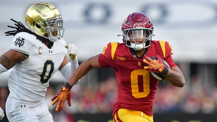 Nov 30, 2024; Los Angeles, California, USA; Southern California Trojans running back Quinten Joyner (0) runs the ball ahead of Notre Dame Fighting Irish safety Xavier Watts (0) during the second half at the Los Angeles Memorial Coliseum. Mandatory Credit: Gary A. Vasquez-Imagn Images
