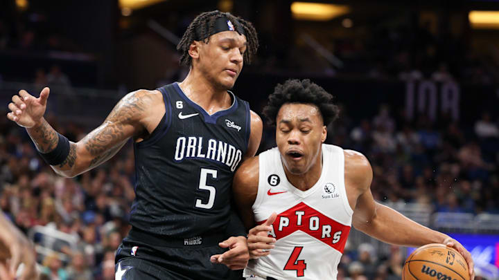 Dec 11, 2022; Orlando, Florida, USA;  Orlando Magic forward Paolo Banchero (5) guards Toronto Raptors forward Scottie Barnes (4) in the first quarter at Amway Center. Mandatory Credit: Nathan Ray Seebeck-Imagn Images