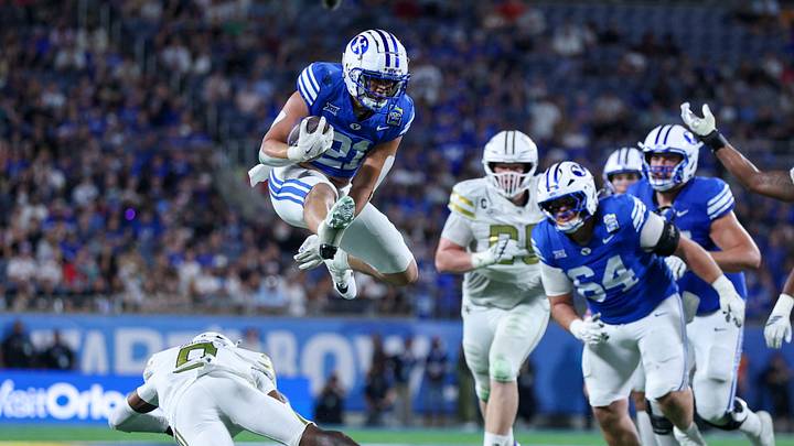 Dec 27, 2025; Orlando, FL, USA; BYU Cougars running back Enoch Nawahine (21) leaps over Georgia Tech Yellow Jackets defensive back Omar Daniels (9) in the fourth quarter during the Pop-Tarts Bowl at Camping World Stadium. Mandatory Credit: Nathan Ray Seebeck-Imagn Images Dec 27, 2025; Orlando, FL, USA; BYU Cougars running back Enoch Nawahine (21) leaps over Georgia Tech Yellow Jackets defensive back Omar Daniels (9) in the fourth quarter during the Pop-Tarts Bowl at Camping World Stadium. Mandatory Credit: Nathan Ray Seebeck-Imagn Images