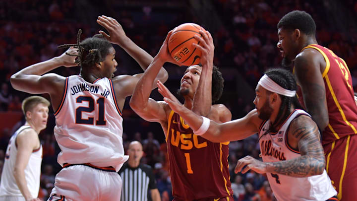 Jan 11, 2025; Champaign, Illinois, USA;  USC Trojans guard Desmond Claude (1) drives to the basket b between Illinois Fighting Illini forward Morez Johnson Jr. (21) and  Kylan Boswell (4) during the second half at State Farm Center. Mandatory Credit: Ron Johnson-Imagn Images
