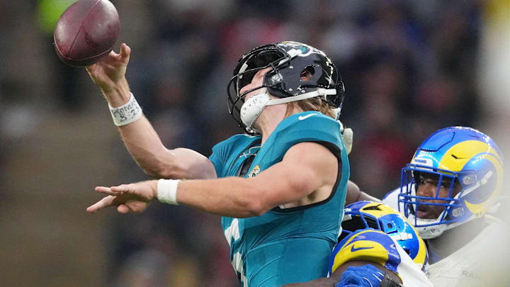 Oct 19, 2025; London, United Kingdom; Los Angeles Rams linebacker Bryon Young (0) tackles Jacksonville Jaguars quarterback Trevor Lawrence (16) during the second half of an NFL International Series game at Wembley Stadium. Mandatory Credit: Kirby Lee-Imagn Images
