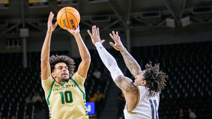 Jan 14, 2025; Wichita, Kansas, USA; Charlotte 49ers guard Nik Graves (10) shoots the ball over Wichita State Shockers guard Justin Hill (11) during the first half at Charles Koch Arena. Mandatory Credit: William Purnell-Imagn Images