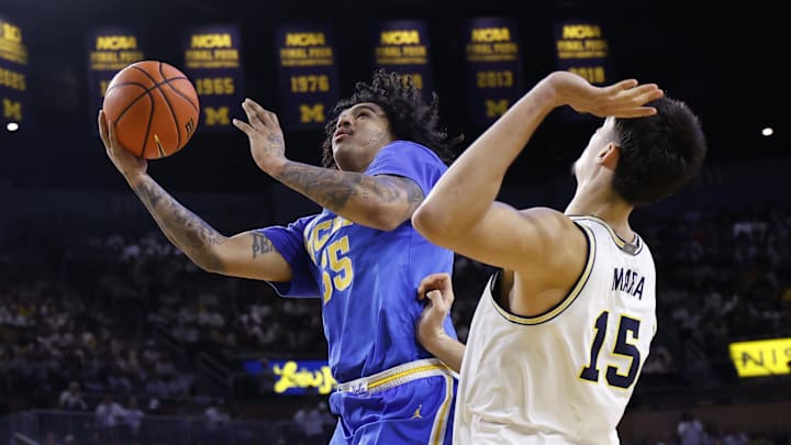 Feb 14, 2026; Ann Arbor, Michigan, USA; UCLA Bruins guard Skyy Clark (55) shoots on Michigan Wolverines center Aday Mara (15) in the second half at Crisler Center. Mandatory Credit: Rick Osentoski-Imagn Images