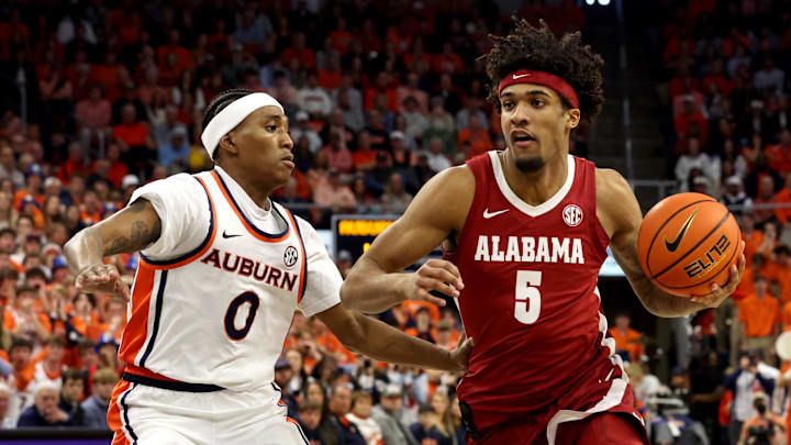 Feb 7, 2026; Auburn, Alabama, USA;  Alabama Crimson Tide forward Amari Allen (5) runs a play as Auburn Tigers guard Tahaad Pettiford (0) defends during the first half at Neville Arena. Mandatory Credit: John Reed-Imagn Images