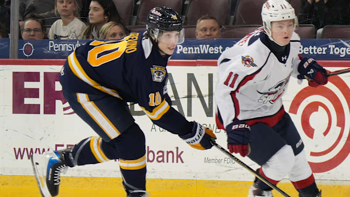 Erie Otters defenseman Tristen Trevino, left, competes near Windsor Spitfires forward Caden Harvey at Erie Insurance Arena in Erie on Jan. 16, 2026.