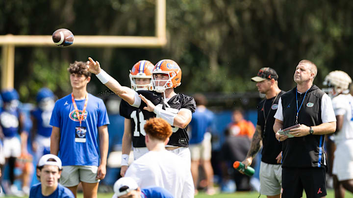 Florida Gators quarterback Graham Mertz (15) throws the ball while Florida Gators head coach Billy Napier looks on during fall football practice at Heavener Football Complex at the University of Florida in Gainesville, FL on Wednesday, July 31, 2024. [Matt Pendleton/Gainesville Sun]