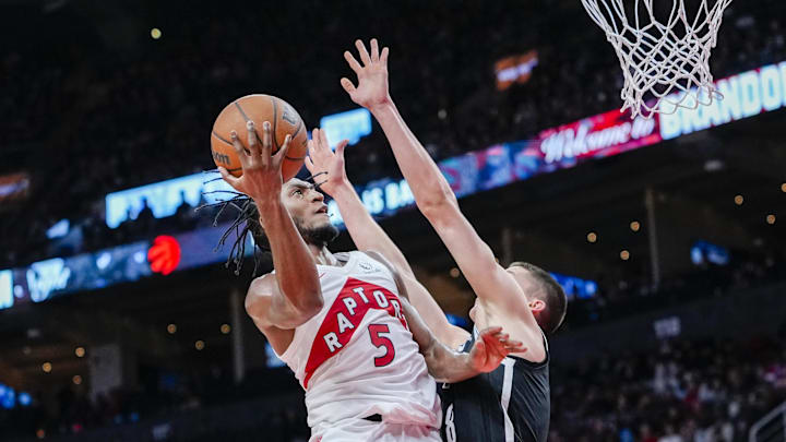 Toronto Raptors guard Immanuel Quickley goes to the basket against Brooklyn Nets guard Egor Dëmin.