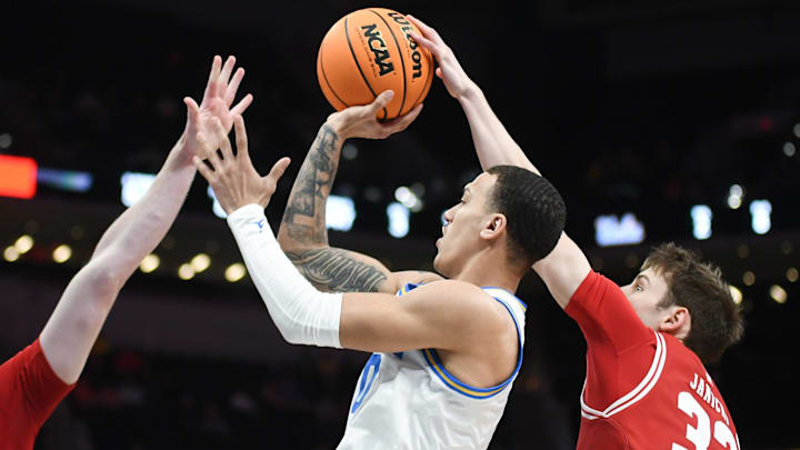 Mar 14, 2025; Indianapolis, IN, USA; Wisconsin Badgers guard Jack Janicki (33) blocks a shot from UCLA Bruins guard Kobe Johnson (0) during the second half at Gainbridge Fieldhouse. Mandatory Credit: Robert Goddin-Imagn Images