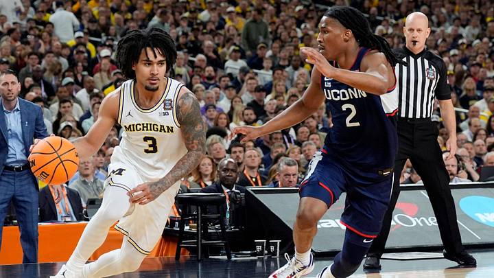Michigan guard Elliot Cadeau dribbles the ball around Connecticut guard Silas Demary Jr. during the first half of the NCAA national championship game at Lucas Oil Stadium in Indianapolis on Monday, April 6, 2026.