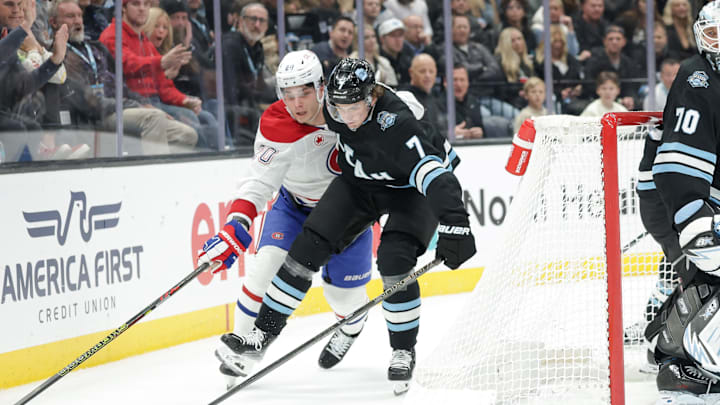Jan 14, 2025; Salt Lake City, Utah, USA;  Utah Hockey Club defenseman Michael Kesselring (7) and Montreal Canadiens left wing Juraj Slafkovsky (20) fight for the puck during the third period at Delta Center. Mandatory Credit: Chris Nicoll-Imagn Images