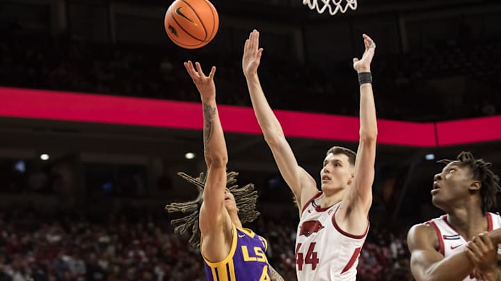 Feb 12, 2025; Fayetteville, Arkansas, USA; LSU Tigers guard Dji Bailey (4) tries to shoot past Arkansas Razorbacks forward Zvonimir Ivisic (44) during the first half at Bud Walton Arena. Mandatory Credit: Brett Rojo-Imagn Images
