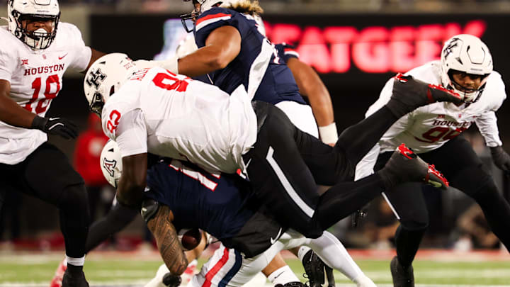 Arizona Wildcats quarterback Noah Fifita (11) gets tackled by Houston Cougars defensive lineman Carlos Allen (92) during the first quarter at Arizona Stadium. Arizona Wildcats quarterback Noah Fifita (11) gets tackled by Houston Cougars defensive lineman Carlos Allen (92) during the first quarter at Arizona Stadium.