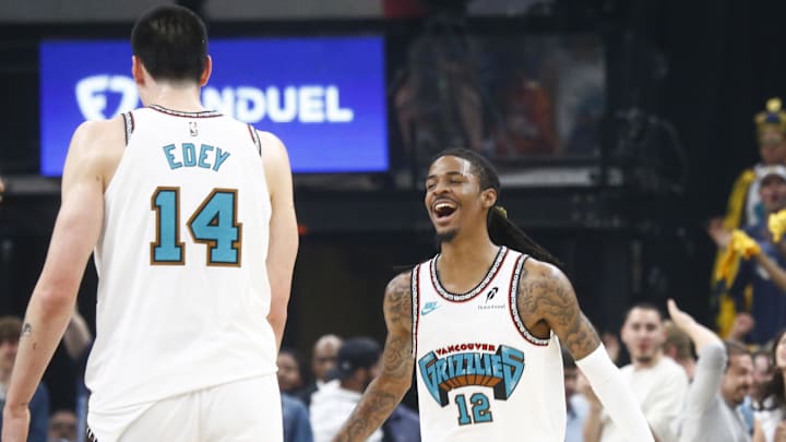 Apr 18, 2025; Memphis, Tennessee, USA; Memphis Grizzlies guard Ja Morant (12) reacts with center Zach Edey (14) during the first quarter against the Dallas Mavericks at FedExForum. Mandatory Credit: Petre Thomas-Imagn Images