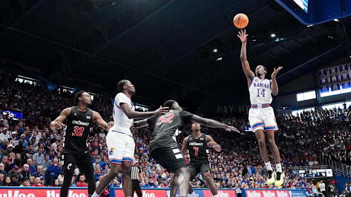 Feb 21, 2026; Lawrence, Kansas, USA; Kansas Jayhawks guard Melvin Council Jr. (14) shoots over Cincinnati Bearcats center Moustapha Thiam (52) during the second half of the game at Allen Fieldhouse. Mandatory Credit: Denny Medley-Imagn Images
