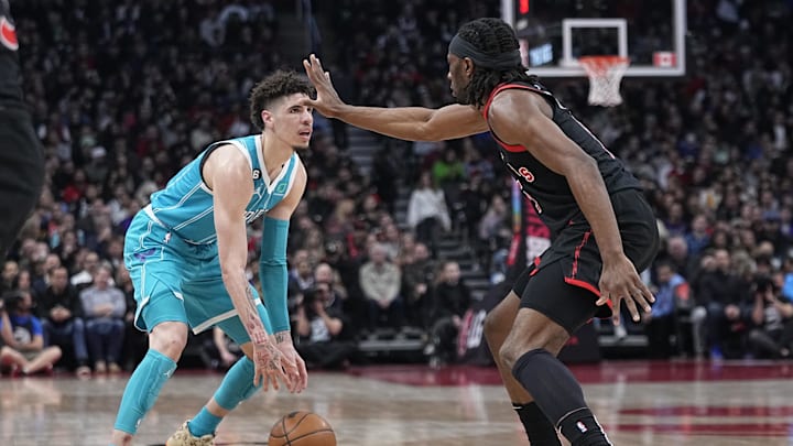 Jan 12, 2023; Toronto, Ontario, CAN; Toronto Raptors forward Precious Achiuwa (5) defends against Charlotte Hornets guard LaMelo Ball (1) during the first half at Scotiabank Arena. Mandatory Credit: John E. Sokolowski-Imagn Images