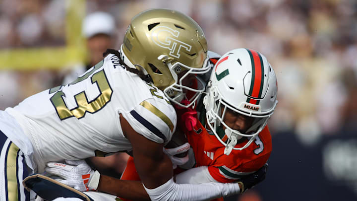 Nov 9, 2024; Atlanta, Georgia, USA; Georgia Tech Yellow Jackets defensive back Zachary Tobe (23) tackles Miami Hurricanes wide receiver Jacolby George (3) in the fourth quarter at Bobby Dodd Stadium at Hyundai Field. Mandatory Credit: Brett Davis-Imagn Images