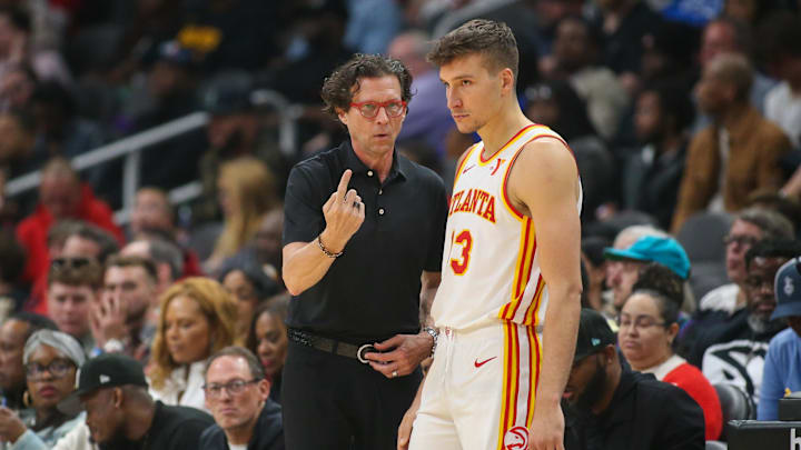 Mar 23, 2024; Atlanta, Georgia, USA; Atlanta Hawks head coach Quin Snyder talks to guard Bogdan Bogdanovic (13) against the Charlotte Hornets in the second quarter at State Farm Arena. Mandatory Credit: Brett Davis-Imagn Images