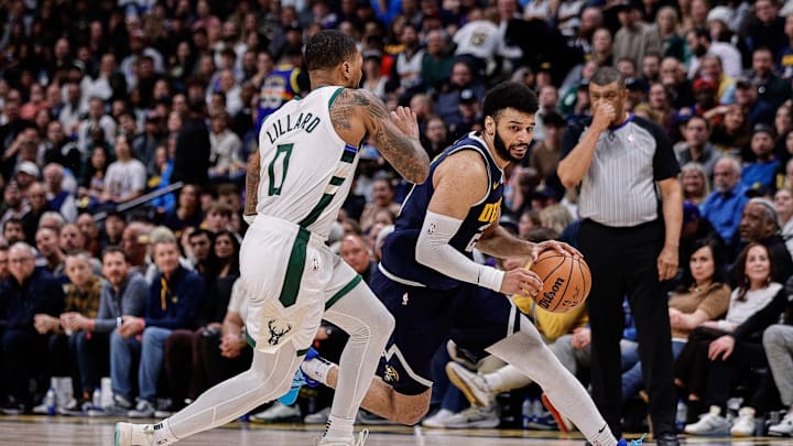 Jan 29, 2024; Denver, Colorado, USA; Denver Nuggets guard Jamal Murray (27) controls the ball as Milwaukee Bucks guard Damian Lillard (0) guards in the fourth quarter at Ball Arena. Mandatory Credit: Isaiah J. Downing-Imagn Images