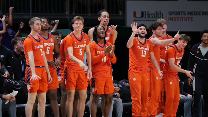 Dec 7, 2024; Coral Gables, Florida, USA; Clemson Tigers forward Asa Thomas (5), guard Del Jones (10) and guard Andrew Latiff (13) celebrate from the bench against the Miami Hurricanes during the second half at Watsco Center. Mandatory Credit: Sam Navarro-Imagn Images