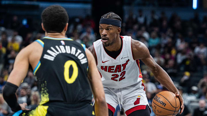Apr 7, 2024; Indianapolis, Indiana, USA;  Miami Heat forward Jimmy Butler (22) dribbles the ball while  Indiana Pacers guard Tyrese Haliburton (0) defends in the second half at Gainbridge Fieldhouse. Mandatory Credit: Trevor Ruszkowski-Imagn Images