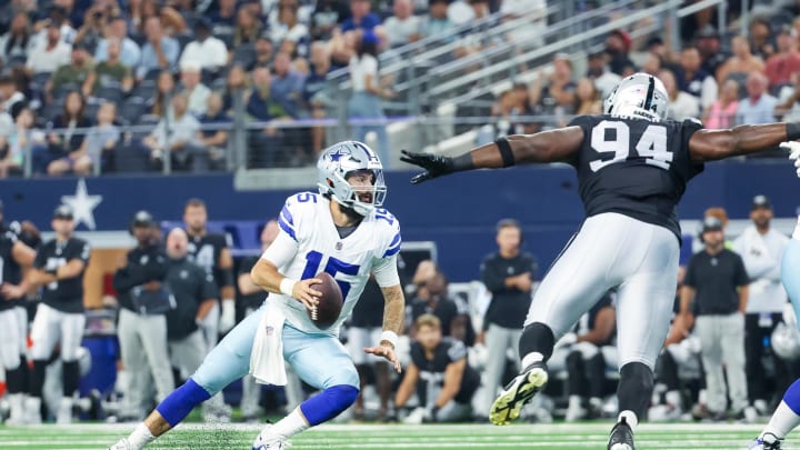 Aug 26, 2023; Arlington, Texas, USA;  Dallas Cowboys quarterback Will Grier (15) evades the rush of Las Vegas Raiders defensive tackle Matthew Butler (94) during the first quarter at AT&T Stadium. Mandatory Credit: Kevin Jairaj-USA TODAY Sports
