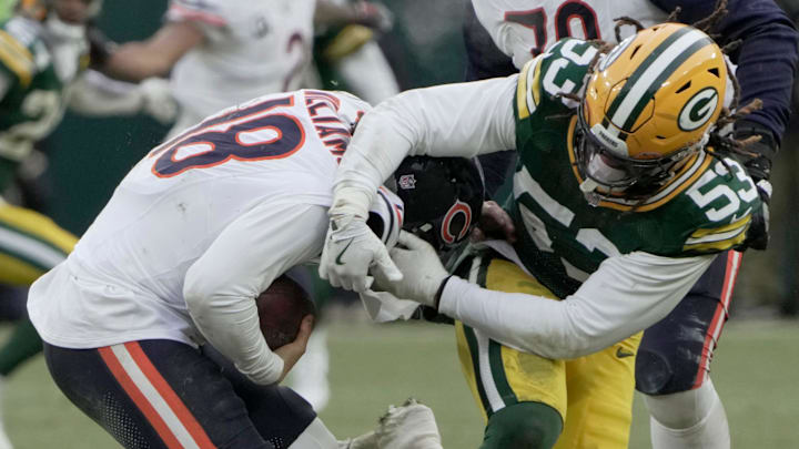 Chicago Bears quarterback Caleb Williams (18) evades a sack by Green Bay Packers defensive end Arron Mosby.