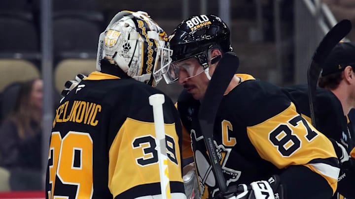 Nov 30, 2024; Pittsburgh, Pennsylvania, USA;  Pittsburgh Penguins goaltender Alex Nedeljkovic (39) and center Sidney Crosby (87) celebrate after defeating the Calgary Flames at PPG Paints Arena. Mandatory Credit: Charles LeClaire-Imagn Images