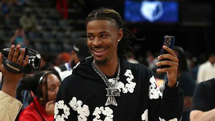 Nov 17, 2024; Memphis, Tennessee, USA; Memphis Grizzlies guard Ja Morant (12) takes videos with his phone after the game against the Denver Nuggets at FedExForum. 