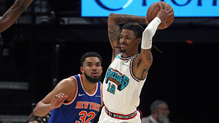 Feb 28, 2025; Memphis, Tennessee, USA; Memphis Grizzlies guard Ja Morant (12) passes the ball as New York Knicks center Karl-Anthony Towns (32) defends during the second quarter at FedExForum. Mandatory Credit: Petre Thomas-Imagn Images