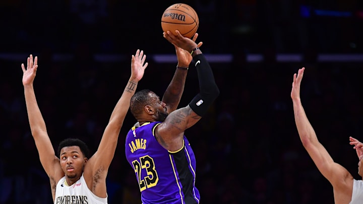 Feb 9, 2024; Los Angeles, California, USA; Los Angeles Lakers forward LeBron James (23) shoots against New Orleans Pelicans guard Trey Murphy III (25) and guard Dyson Daniels (11) during the second half at Crypto.com Arena. Mandatory Credit: Gary A. Vasquez-Imagn Images