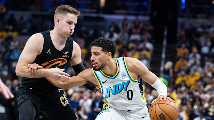 May 11, 2025; Indianapolis, Indiana, USA; Indiana Pacers guard Tyrese Haliburton (0) dribbles the ball while Cleveland Cavaliers guard Sam Merrill (5) defends during game four of the second round for the 2025 NBA Playoffs at Gainbridge Fieldhouse. Mandatory Credit: Trevor Ruszkowski-Imagn Images