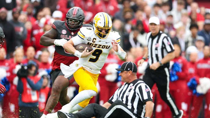 Nov 22, 2025; Norman, Oklahoma, USA;  Missouri Tigers quarterback Beau Pribula (9) runs past Oklahoma Sooners defensive lineman David Stone (0) as an official falls down during the first quarter at Gaylord Family-Oklahoma Memorial Stadium. Mandatory Credit: Kevin Jairaj-Imagn Images