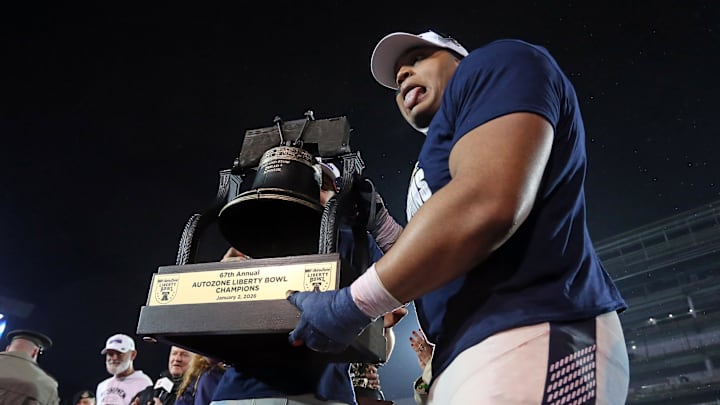 Jan 2, 2026; Memphis, TN, USA; Navy Midshipmen defensive lineman Landon Robinson (96) reacts while holding the Liberty Bowl trophy after defeating the Cincinnati Bearcats in the Liberty Bowl at Simmons Bank Liberty Stadium. Mandatory Credit: Petre Thomas-Imagn Images