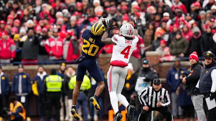 Michigan Wolverines defensive back Jyaire Hill (20) intercept a pass intended for Ohio State Buckeyes wide receiver Jeremiah Smith (4) in the first half of the NCAA football game at Michigan Stadium on Saturday, Nov. 29, 2025 in Ann Arbor, Michigan.
