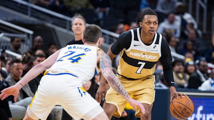Dec 14, 2025; Indianapolis, Indiana, USA; Washington Wizards guard Bub Carrington (7) dribbles the ball while  Indiana Pacers guard Garrison Mathews (24) defends in the second half at Gainbridge Fieldhouse. Mandatory Credit: Trevor Ruszkowski-Imagn Images