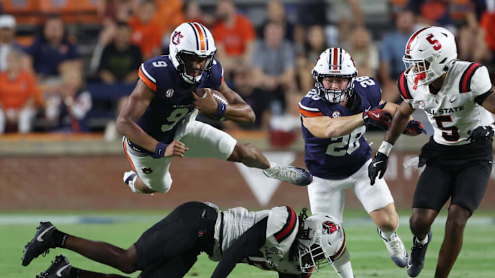 Sep 6, 2025; Auburn, Alabama, USA;  Auburn Tigers quarterback Deuce Knight (9) gets airborne over Ball State Cardinals defensive back Derek Fields (15) during the fourth quarter at Jordan-Hare Stadium. Mandatory Credit: John Reed-Imagn Images