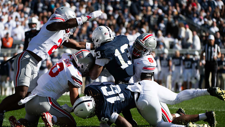 Penn State running back Kaytron Allen (13) is tackled by Ohio State's Cody Simon (0) and Sonny Styles (6) in the first half at Beaver Stadium.