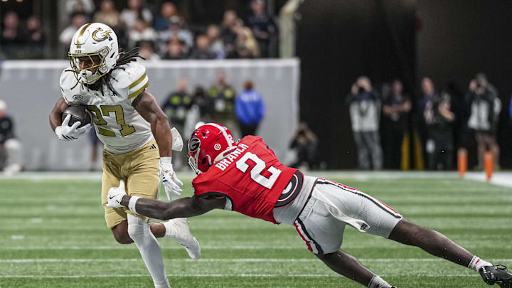 Nov 28, 2025; Atlanta, Georgia, USA; Georgia Tech Yellow Jackets running back Chad Alexander (27) runs against Georgia Bulldogs safety Zion Branch (2) during the second half at Mercedes-Benz Stadium. Mandatory Credit: Dale Zanine-Imagn Images